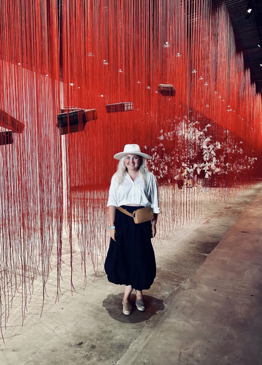 Barbara standing inside a red thread art installation